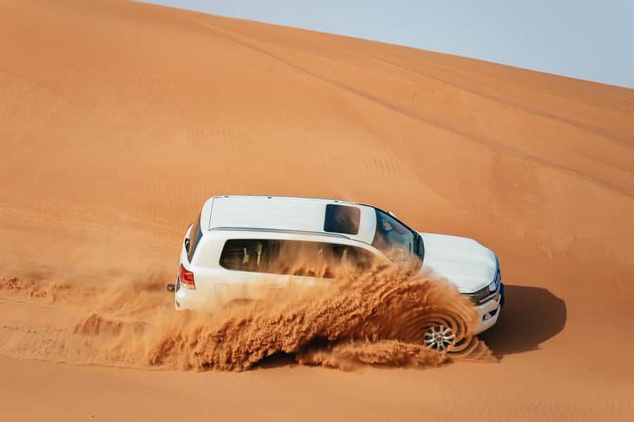 Dubai: Desert Safari, Camel Ride, Sandboarding, Quad Bike - Hotel Pickup in a 4WD and the Route Out of Dubai