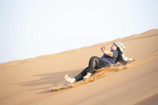 Dubai Half-day Red Dunes bashing with Sandboarding, Camel &Falcon - Sandboarding right after dune bashing